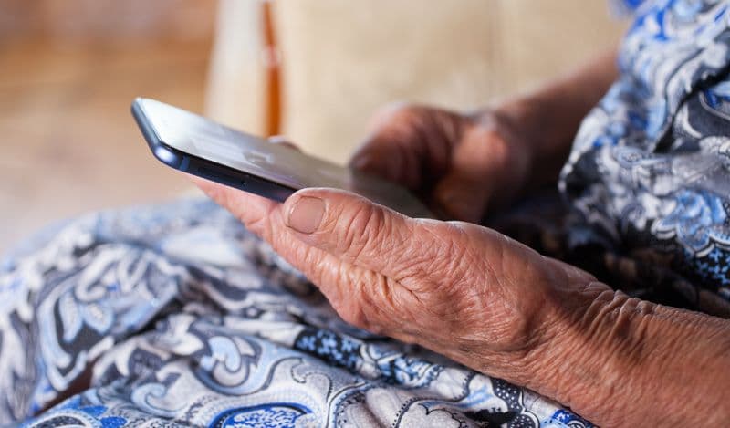 Elderly hands holding a smart phone